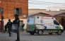This picture released by APG Noticias shows police officers standing near an ambulance at the site of an explosion at an army barracks in Viacha, Bolivia, on September 4, 2026.  (Photo by APG NOTICIAS / AFP)