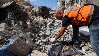 A Civil Defence member collects human remains in the rubble of Al-Muhandisin Tower, that was destroyed in Israeli strikes in the Nuseirat camp for refugees in the central Gaza Strip on September 5, 2026. (Photo by Eyad BABA / AFP)