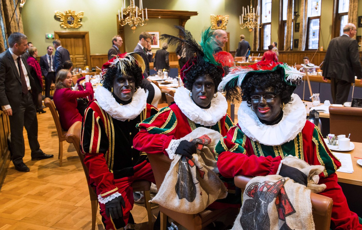 This file photo taken on November 5, 2014 shows (L-R) Dutch right wing PVV State members Ton van Kesteren, Matthijs Jansen and Dennis Ram dressed as Black Pete, the jolly sidekick of the Dutch Saint Nicholas, attending a meeting in the Province House in G