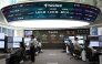Currency dealers monitor exchange rates in front of a screen showing South Korea's benchmark stock index and the Korean won/USD exchange rate in a foreign exchange dealing room at the Hana Bank headquarters in Seoul on October 27, 2025. (Photo by Jung Yeon-je / AFP)