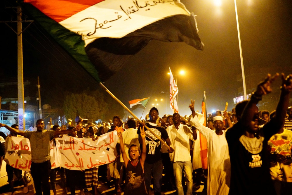 FILE PHOTO: Sudanese people, seeking to revive a push for civilian rule in ongoing tumult since the overthrow of former President Omar al-Bashir more than two months ago, chant slogans and wave Sudanese flags during a demonstration in Khartoum, Sudan, Jun