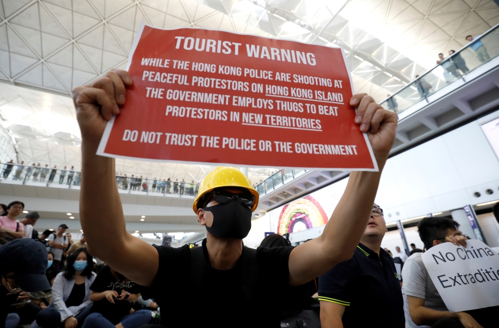 A demonstrator holds a banner during a protest against the recent violence in Yuen Long, at Hong Kong airport, China July 26, 2019. REUTERS/Edgar Su