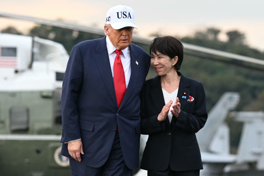 US President Donald Trump and Japan's Prime Minister Sanae Takaichi arrive on board the US Navy's USS George Washington aircraft carrier at the US naval base in Yokosuka on October 28, 2025. (Photo by Andrew Caballero-Reynolds / AFP)