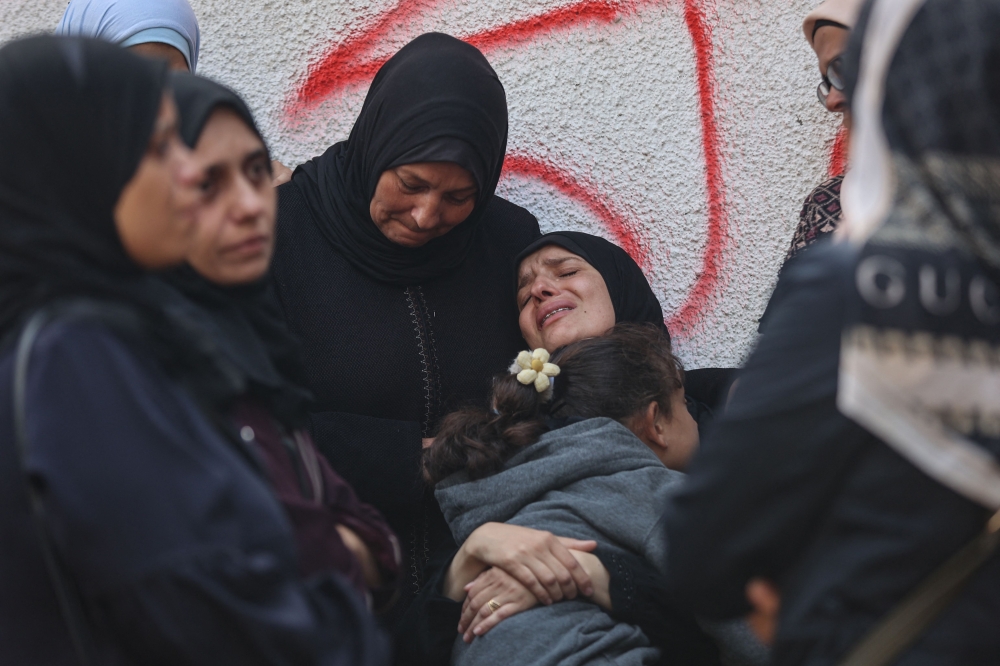 Palestinians mourn the death of loved ones killed in overnight Israeli strikes at the Al-Shifa Hospital in Gaza City on October 29, 2025. (Photo by Omar Al-Qattaa / AFP)